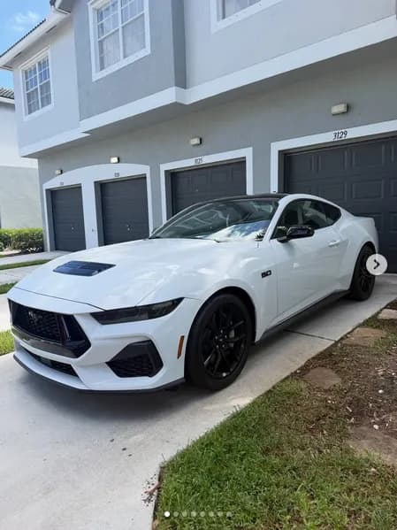 A white Ford Mustang, detailed outside the owner’s garage